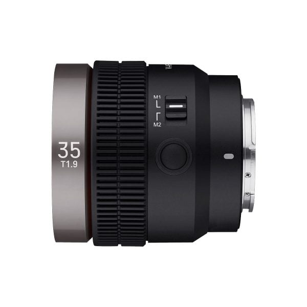 Samyang V-AF 35mm T1.9 for Sony FE on musta kameraobjektiivi, jossa on mattahopea rengas, jossa lukee "35 T1.9". Siinä on manuaali- ja lukituskytkimet, kuvioitu tarkennusrengas ja metallinen kiinnitysjalusta, jotka näkyvät valkoisella pohjalla.