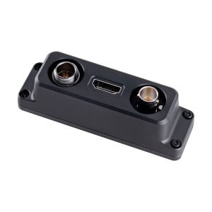 DJI Remote Monitor Expansion Plate (SDI/HDMI/DC-IN) on musta suorakulmainen elektroninen moduuli, jossa on pyöreä liitin vasemmalla, HDMI-portti keskellä ja toinen pyöreä liitin oikealla, ja jossa on kulmissa ruuvinreiät kiinnitystä varten.
