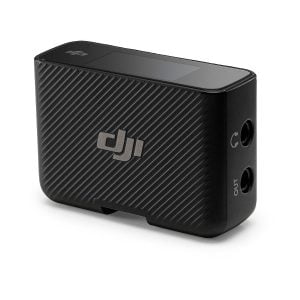 The DJI Mic Dual Kit wireless microphone system is a compact black transmitter with a textured diagonal striped design, two 3.5mm input/output ports, a small top screen and the DJI logo on the side.