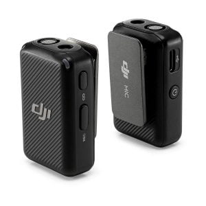 The two black DJI Mic Dual Kit Wireless Microphone System transmitters feature textured surfaces, side buttons and visible DJI logos. One shows a power button and USB port; the other has a holder with DJI MIC labeling.