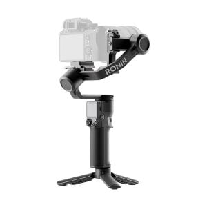 DJI RS 3 Mini -gimbaali, jossa on merkintä "RONIN", näkyy mustana, ja sen yläosaan on asennettu kamera ja alaosassa on irrotettava jalusta. Kamera näkyy hieman haalistuneena korostaakseen kardaanivakauttajaa.
