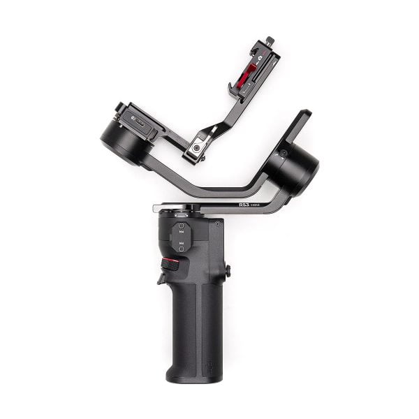 DJI RS 3 Mini -gimbaali on mustalla kädessä pidettävä kameranvakain, jossa on ergonominen kahva, ohjauspainikkeet ja L-muotoinen kiinnike kameran kiinnittämistä varten, kuvassa valkoista taustaa vasten.