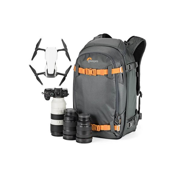 Lowepro Whistler BP 350 AW II GL -kamerareppu harmaalla ja oranssilla värillä näkyy valkoisella taustalla, ja sen ympärille on järjestetty valkoinen lennokki, musta kamera ja objektiivi sekä kolme ylimääräistä objektiivia.