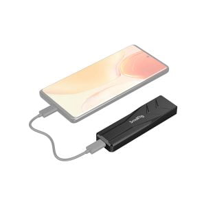 Älypuhelin on liitetty kaapelilla suorakulmaiseen mustaan SmallRig 3479 M.2 SSD-koteloon SD-01 valkoisella pohjalla.