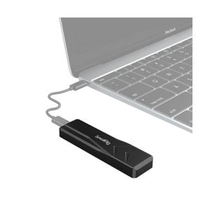 SmallRig 3479 M.2 SSD Enclosure SD-01, musta USB-laite, on liitetty kannettavaan tietokoneeseen lyhyellä USB-kaapelilla, ja kannettavan tietokoneen näppäimistön ja ohjauslevyn osat ovat osittain näkyvissä.
