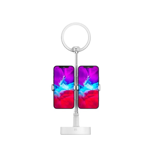 SmallRig 3242 Selection Portable LED-valaisin L10, jossa on pyöreä rengasvalo valkoisen säädettävän jalustan ja neliönmuotoisen pohjan päällä, pitää sisällään kaksi älypuhelinta vierekkäin, joissa molemmissa näkyy elävä sininen ja vaaleanpunainen abstrakti näyttö.