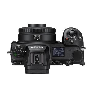 Nikon-kameran yläkuva, jossa on Nikkor Z 26mm f/2.8 -objektiivi, jossa on säätöpyörät, painikkeet ja kameran asetuksia näyttävä näyttö.