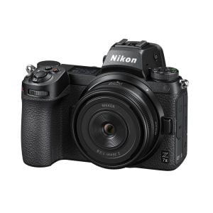 Musta Nikon Z7 II -peilitön kamera, johon on kiinnitetty Nikon Nikkor Z 26mm f/2.8 -objektiivi, edestä kuvattuna valkoista taustaa vasten.
