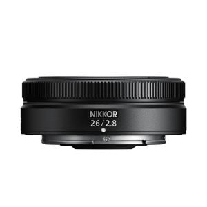 Pienikokoinen musta Nikon Nikkor Z 26mm f/2.8 -objektiivi näkyy valkoista taustaa vasten, ja siinä on kuvioitu tarkennusrengas ja "26/2.8"-merkintä etupuolella.