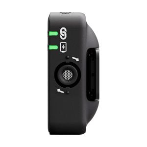 Rode_Wireless_ME_005 Lähikuvassa Rode Wireless ME -langaton mikrofonijärjestelmä näyttää vihreät merkkivalot, salamakuvakkeen, pyöreän aukon, jossa on nuolia, ja liukupainikkeen sen mustalla puolella valkoista taustaa vasten.