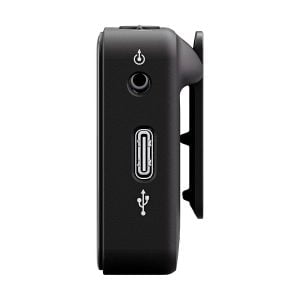 Rode_Wireless_ME_006 Sivukuva Rode Wireless ME -langaton mikrofonijärjestelmä mustana, jossa on virtapainike, pyöreä portti ja USB-portti. Oikealla puolella on klipsikiinnitys valkoista taustaa vasten.