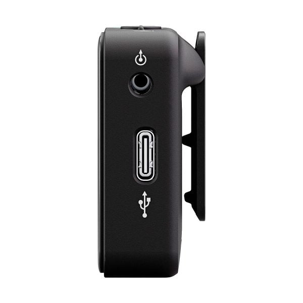 Rode_Wireless_ME_006 Sivukuva Rode Wireless ME -langaton mikrofonijärjestelmä mustana, jossa on virtapainike, pyöreä portti ja USB-portti. Oikealla puolella on klipsikiinnitys valkoista taustaa vasten.