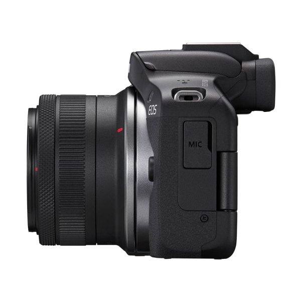 Sivukuva Canon EOS R50 -digitaalikamerasta, jossa on RF-S 18-45mm F4.5-6.3 IS STM -objektiivi, kuvioitu kahva, MIC-merkityt porttisuojat ja osittain näkyvä "EOS" kahvan yläpuolella. Nyt saatavana 100€ alennuksella.