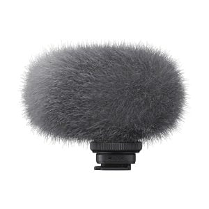 Harmaa, pörröinen tuulisuoja peittää Sony ECM-G1Z -langaton mikrofoni, kompakti mikrofoni, jossa on musta kiinnitysalusta, kuvassa eristettynä valkoisella pohjalla.