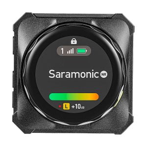 Lähikuva Saramonic BlinkMe B2 -langaton mikrofonijärjestelmä-lähettimestä, jossa on digitaalinen näyttö, jossa näkyy signaalin voimakkuus, pariston tila, lukituskuvake ja +10 dB:n äänitasomittari, jossa on vihreä ja keltainen palkki.