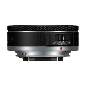Canon RF 28mm f/2.8 STM -objektiivin sivukuva, jossa näkyy sen kuvioitu tarkennusrengas, MF/AF-säätökytkin ja metallinen kiinnitysjalusta. Pääosin mustassa objektiivissa on hopeisia korostuksia lähellä jalustaa.