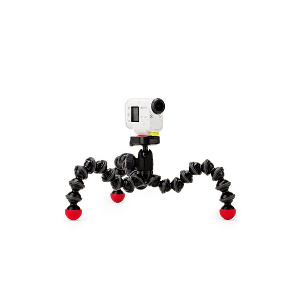 JOBY GorillaPod Action GoPro Jalusta, pieni valkoinen toimintakamera, joka on asennettu joustavaan mustaan jalustaan, jossa on neljä taipuisaa jalkaa ja punaiset kumijalat, näkyy tavallista valkoista taustaa vasten.