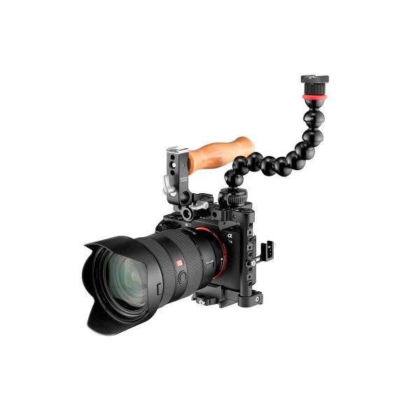A professional digital camera with a large lens, mounted in a cage with a wooden handle and topped with a JOBY GorillaPod Arm Kit PRO Black, all against a white background.