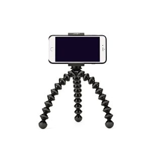 JOBY GripTight GorillaPod Stand PRO Jalusta Puhelimelle, musta taipuisa kolmella segmentoidulla taipuisalla jalalla varustettu kolmijalkainen jalusta, pitää älypuhelinta pystyssä valkoista taustaa vasten.