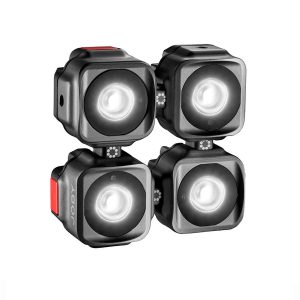 Joby-Beamo-Mini-5 Neljä Joby Beamo Mini LED-valoa, jotka ovat kompakteja ja neliönmuotoisia ja joissa on pyöristetyt reunat, on sijoitettu 2x2-ruudukkoon; jokaisessa on hehkuva pyöreä keskus ja pieni punainen painike sivulla.