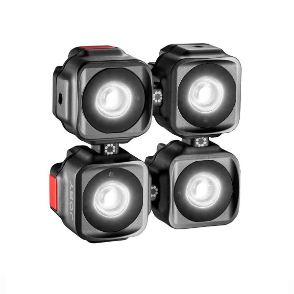 Joby-Beamo-Mini-5 Neljä Joby Beamo Mini LED-valoa, jotka ovat kompakteja ja neliönmuotoisia ja joissa on pyöristetyt reunat, on sijoitettu 2x2-ruudukkoon; jokaisessa on hehkuva pyöreä keskus ja pieni punainen painike sivulla.