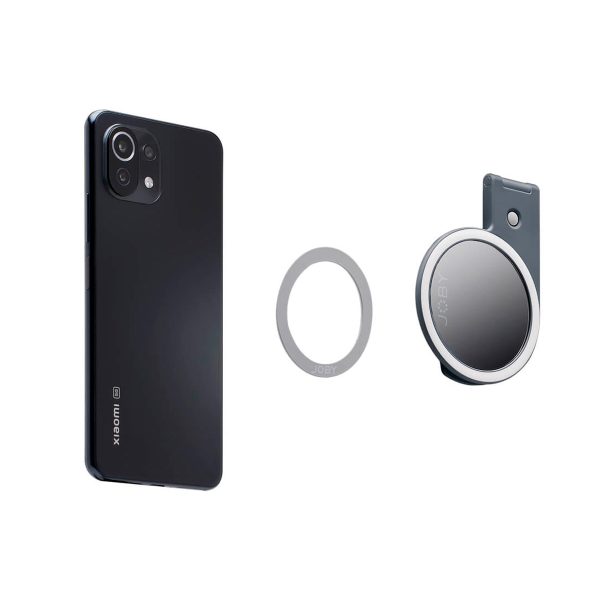 Harmaan Joby Beamo Ring Light for MagSafe on esillä valkoista taustaa vasten yhdessä mustan älypuhelimen ja pyöreän magneettipuhelinpidikkeen kanssa, jossa on klipsi.