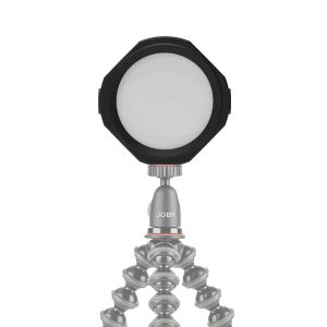 Joby Beamo Studio Background LED-valo on kompakti, pyöreä LED, joka on asennettu joustavaan jalustaan, jossa on segmentoidut, taivutettavat jalat. JOBY-logo näkyy jalustassa valkoista taustaa vasten.