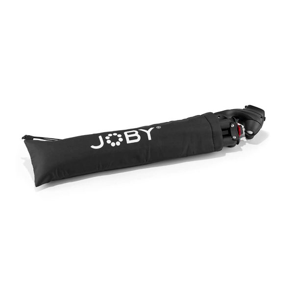 Joby-merkkisessä mustassa kantolaukussa on Joby Compact Action 3K -jalusta, joka on osittain näkyvissä vetoketjullisesta päädystä ulosvedettynä.