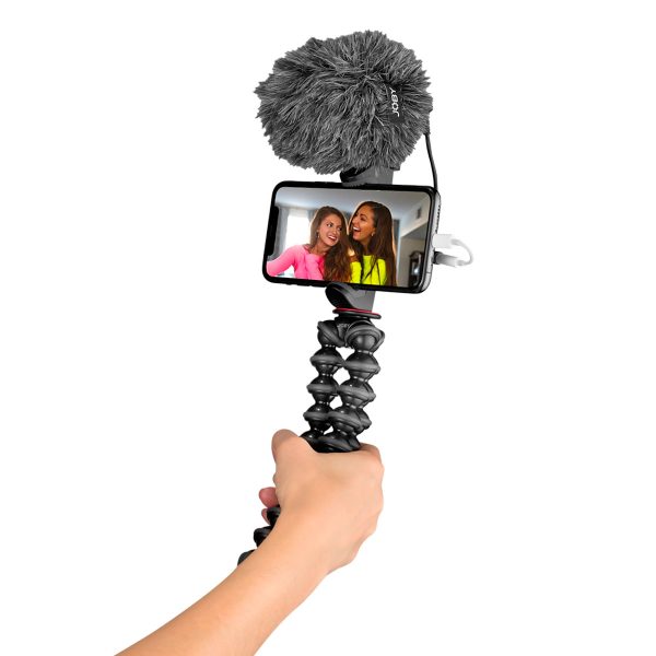The hand-held Joby GorillaPod Creator Kit, which supports a smartphone with an external microphone, displays two women smiling on the screen for a selfie or video.