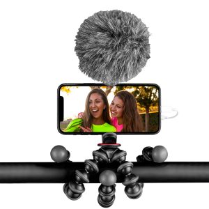 The Joby GorillaPod Creator Kit holds a smartphone with a furry microphone and captures two smiling women in bright clothes outside.