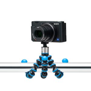 Musta Sony-digitaalikamera on kiinnitetty Joby GorillaPod Go 500 + GripTight 360 Tripod Kit Blue -jalustapakettiin, joka on kiinnitetty turvallisesti metallisen vaakatangon ympärille.
