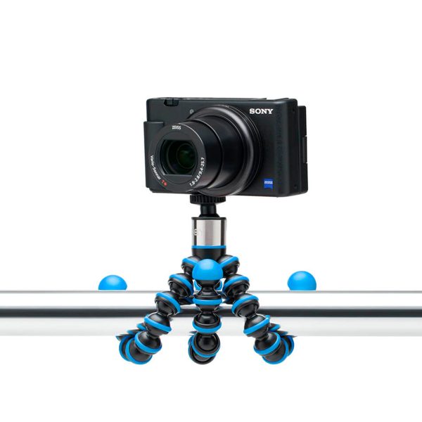 Musta Sony-digitaalikamera on kiinnitetty Joby GorillaPod Go 500 + GripTight 360 Tripod Kit Blue -jalustapakettiin, joka on kiinnitetty turvallisesti metallisen vaakatangon ympärille.