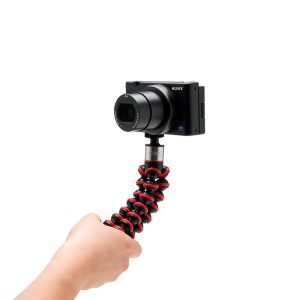 Joby-GorillaPod-Go-500-+-GripTight-360-Tripod-Kit-Red-3 Käsi pitää Joby GorillaPod Go 500 + GripTight 360 Tripod Kit Red -jalustaa, johon on kiinnitetty Sony-kompaktikamera, valkoista taustaa vasten.
