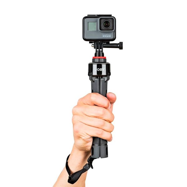 Käsi pitää Joby GripTight Pro TelePodia, johon on kiinnitetty GoPro-toimintakamera valkoista taustaa vasten.