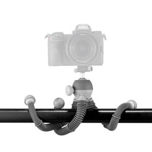 Taivutettavilla jaloilla varustettu Joby PodZilla Flexible Tripod Large on kiedottu vaakasuoran mustan tangon ympärille, ja se pitää kameraa turvallisesti sen säädettävän kuulapääkiinnikkeen avulla valkoista taustaa vasten.