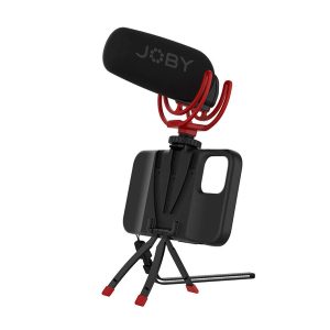 Joby StandPoint iPhone 12 & 12 Pro - kotelo on kompakti älypuhelimen jalustakotelo, johon on asennettu mikrofoni ja punainen iskunvaimennin, ihanteellinen mobiiliin videokuvaukseen tai vloggaukseen. Puhelimen pidikkeessä ja jalustassa on mustat ja punaiset korostukset.