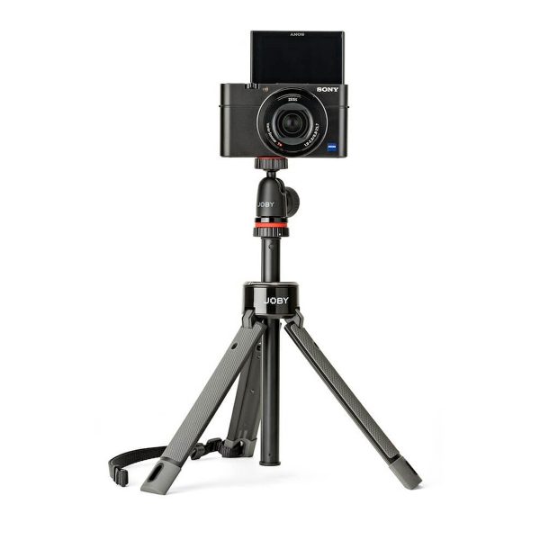 A black Sony digital camera with a swivel screen is mounted on a compact Joby TelePod Pro Kit stand with a carrying strap on one leg, against a white background.