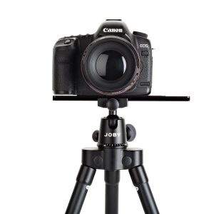 Canon EOS DSLR -kamera, jossa on suuri objektiivi, on kiinnitetty Joby Ultraplate 208 -pikalevyyn valkoista taustaa vasten.