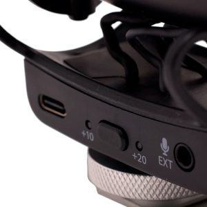 Joby Wavo Pro - Mikrofoni -kuulokkeen lähikuvasta paljastuu USB-C-portti, kytkin +10- ja +20-asetuksilla, EXT-tulon merkkivalo, jossa on mikrofonikuvake, sekä selkeät mustat ja hopeiset komponentit.
