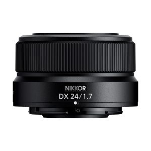 Lähikuva mustasta Nikon Nikkor Z DX 24mm f/1.7 -objektiivista, jonka sivulla on valkoinen malliteksti, valkoista taustaa vasten.