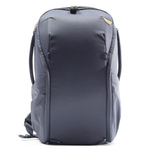Peak Design Everyday Backpack Zip 20L -kamerareppu tummansinisellä värillä, jossa on kaarevat linjat, sivutaskut ja kantokahva ylhäällä, kuvassa pystyasennossa valkoista taustaa vasten.