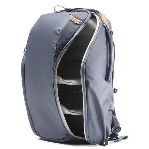 Peak Design Everyday Backpack Zip 20L -kamerareppu, tummansininen, on esitetty pystyssä, kun sen päälokero on avattu vetoketjulla, jolloin paljastuu useita sisäosioita ja pehmustetut väliseinät organisoitua säilytystä varten.