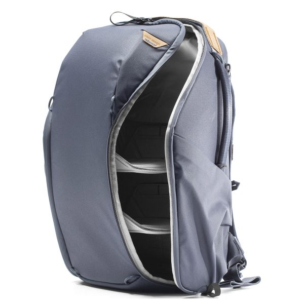 Peak Design Everyday Backpack Zip 20L -kamerareppu, tummansininen, on esitetty pystyssä, kun sen päälokero on avattu vetoketjulla, jolloin paljastuu useita sisäosioita ja pehmustetut väliseinät organisoitua säilytystä varten.