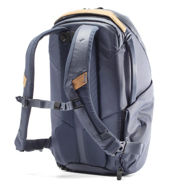 Peak Design Everyday Backpack Zip 20L -kamerareppu tummansinisellä värillä sisältää pehmustetut olkahihnat, rintahihnan, ruskehtavat korostukset ja modernin muotoilun, jossa on useita lokeroita ja vetoketjuja, kuvassa pystyasennossa valkoisella pohjalla.