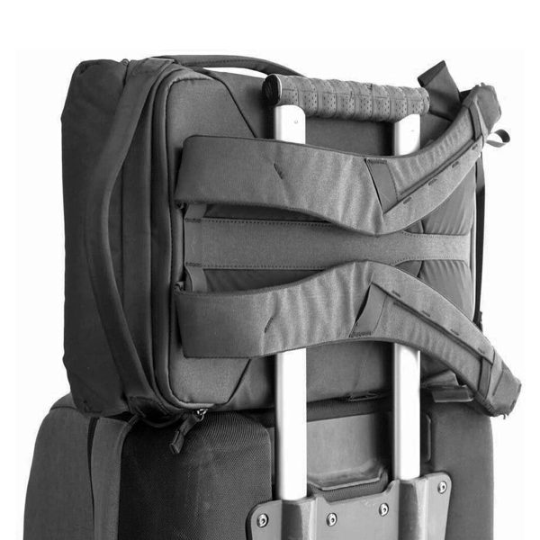 Peak Design Everyday Backpack v2 30L -kamerareppu, musta on kiinnitetty turvallisesti suuremman rullalaukun teleskooppikahvaan, mikä osoittaa käytännöllisen pinoamisratkaisun matkustamiseen.