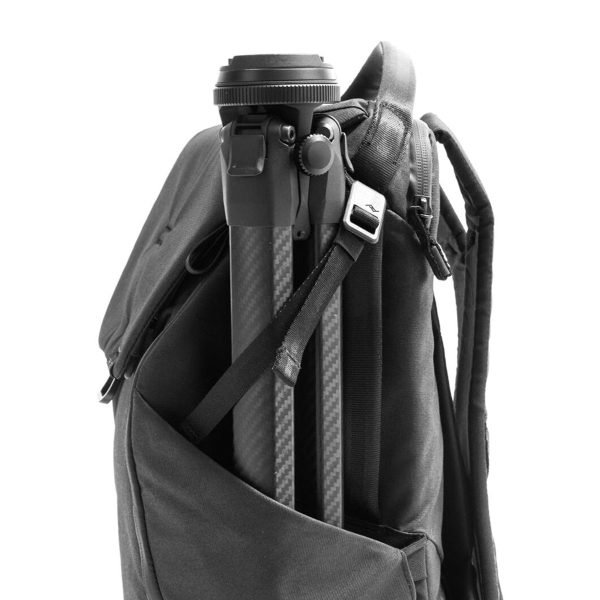 Peak Design Everyday Backpack v2 30L -kamerareppu, musta, on kuvassa sivutasku, jossa on kompakti mustan ja hopeanvärinen kolmijalka, joka on kiinnitetty hihnalla, valkoista taustaa vasten.