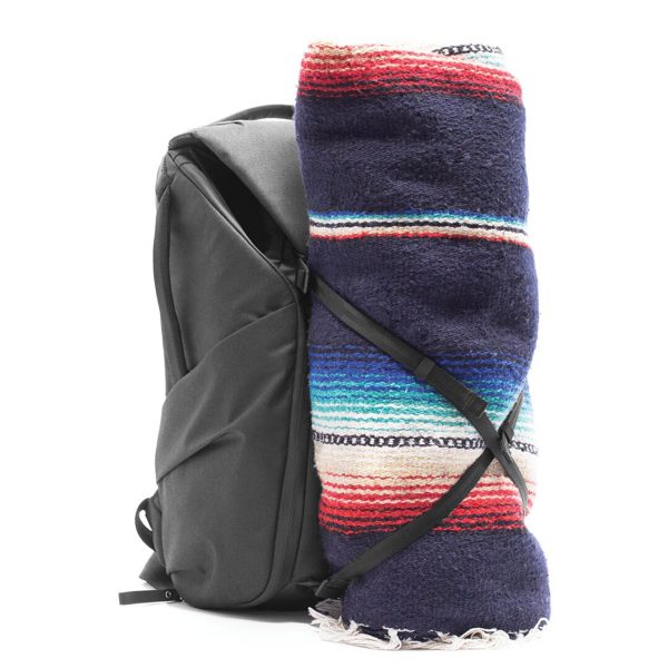 Peak Design Everyday Backpack v2 30L -kamerareppu, musta, sisältää värikkään raidallisen huovan, joka on rullattu kokoon ja kiinnitetty sivulle mustilla hihnoilla, kuvassa valkoista taustaa vasten.