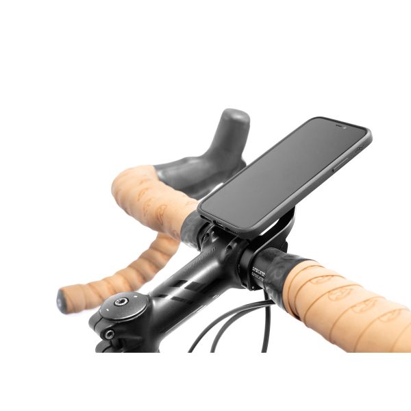 Peak Design Mobile Out Front Bike Mount pitää älypuhelimen polkupyörän ohjaustangossa ruskealla teipillä valkoista taustaa vasten.