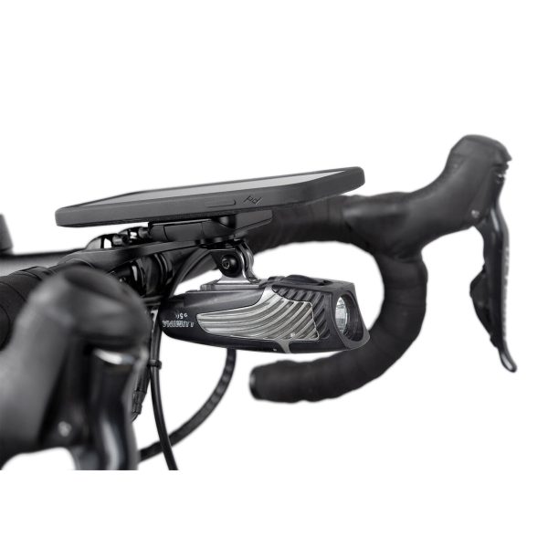Lähikuva teipillä päällystetystä mustasta ohjaustangosta, jossa on Peak Design Mobile Out Front Bike Mount -pyöräkiinnike, jonka yläosassa on pyörätietokone ja alapuolella etuvalo.