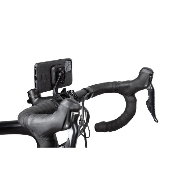 Peak Design Mobile Out Front Bike Mount kiinnittää mustan älypuhelimen kuljettajaan päin polkupyörän mustaan ohjaustankoon ja jarruvipuihin valkoista taustaa vasten.
